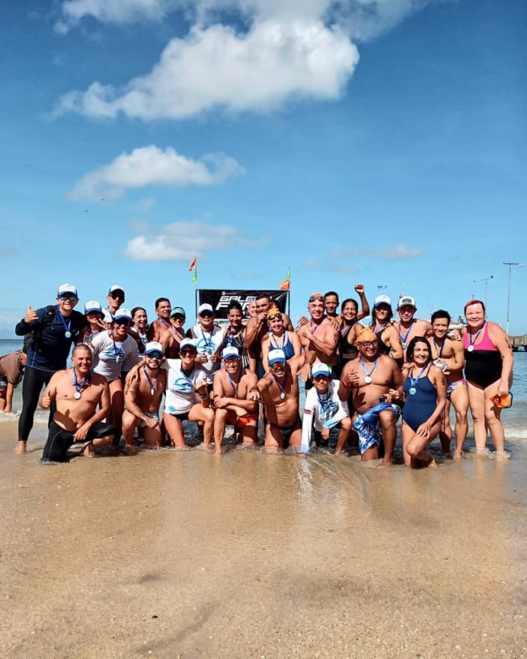 Grupo de participantes en la playa después de una travesía de aguas abiertas