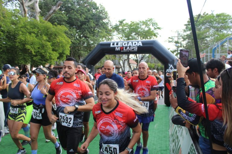 Corredores con dorsal y chip cruzando la alfombra de salida